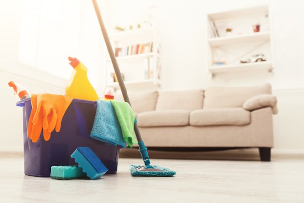 Bucket with sponges, chemicals bottles, mopping stick, rubber gloves and towel. Household equipment, spring-cleaning, tidying up, cleaning service concept, copy space