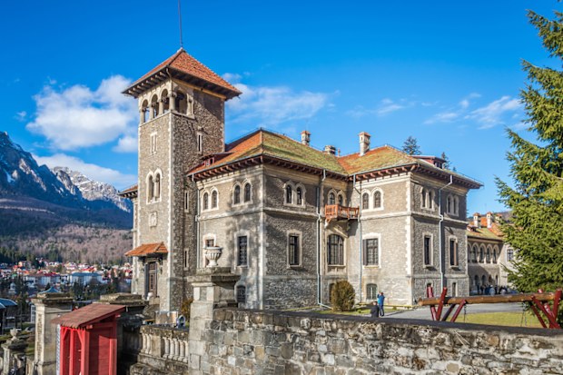 Cantacuzino Castle and the Carpathian Mountains in a sunny day. Residence and museum in a Transylvanian Busteni city, Romania