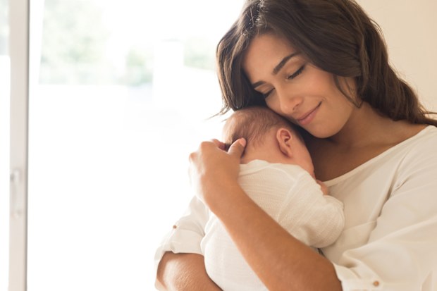 New mum holding a newborn baby in her arms