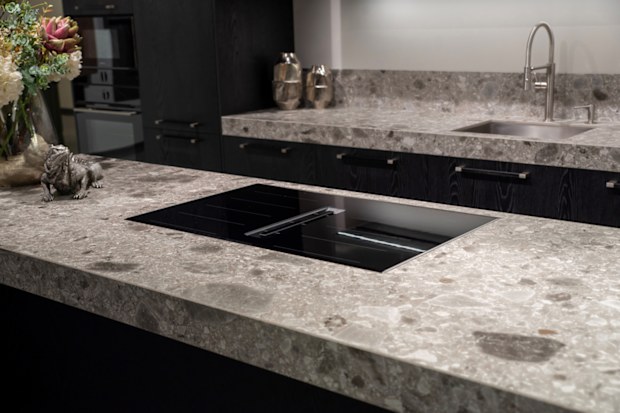 Black induction cooktop with built-in ventilation system on stone worktop