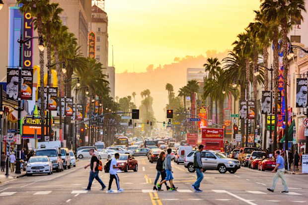 LOS ANGELES, CALIFORNIA - MARCH 1, 2016: Traffic on Hollywood Boulevard at dusk. The theater district is famous tourist attraction.