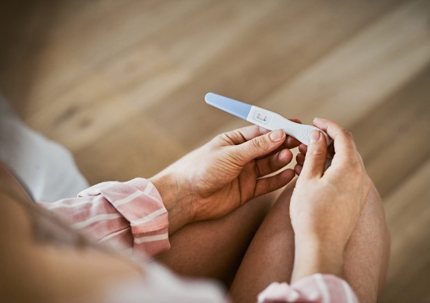 Woman holding a pregnancy test.