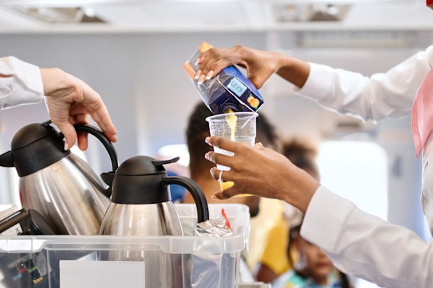 Cabin crew pushing service cart and serve to customer on the airplane during flight
