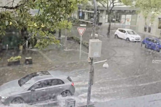 A flash of heavy rain forced planes to divert, streets to flood and ceilings to collapse in Sydney.
