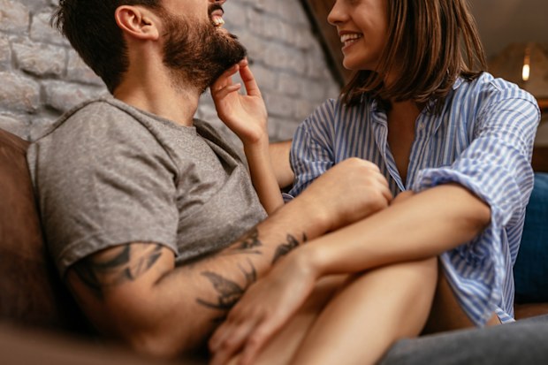 Cropped shot of a happy young couple cuddling in the living room