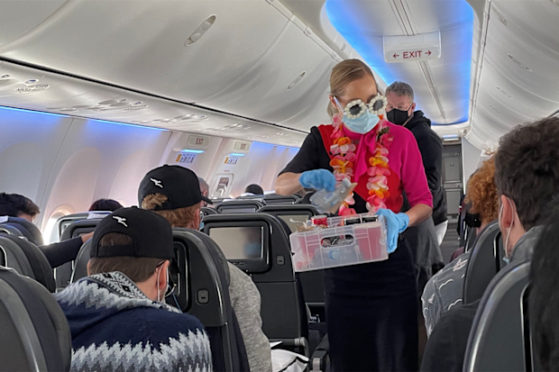 Staff don tropical sunglasses and leis on the second Qantas Mystery Flight to Hamilton Island
