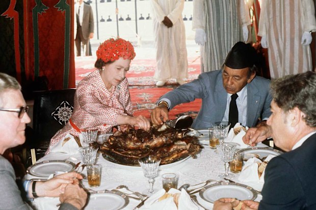 Queen Elizabeth II eats with her hands in the desert with King Hassan during her visit to Morocco on October 27, 1980.