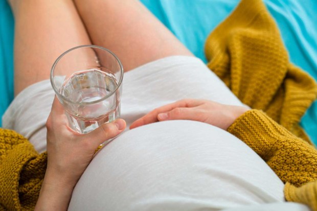 Pregnant woman drinking glass of water