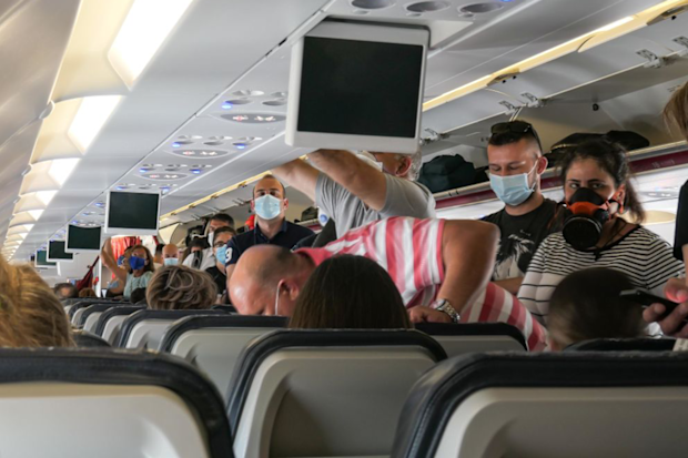 Passengers in face masks board a plane