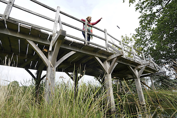 Britain Pooh Bridge Auction: Silke Lohmann of Summers Place Auctions stands on the original Poohsticks Bridge from Ashdown Forest, featured in AA Milne's Winnie the Pooh books and EH Shepard's illustrations.