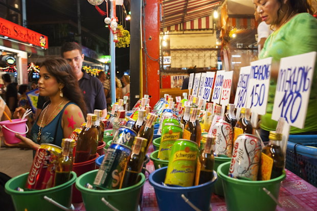 Haad Rin, Ko Phangan, Thailand - August 29, 2007: A Thai woman sells buckets of soft drinks and liquor to visitors celebrating the monthly Full Moon Party in Haad Rin, a beach destination on the island of Ko Phangan, Thailand