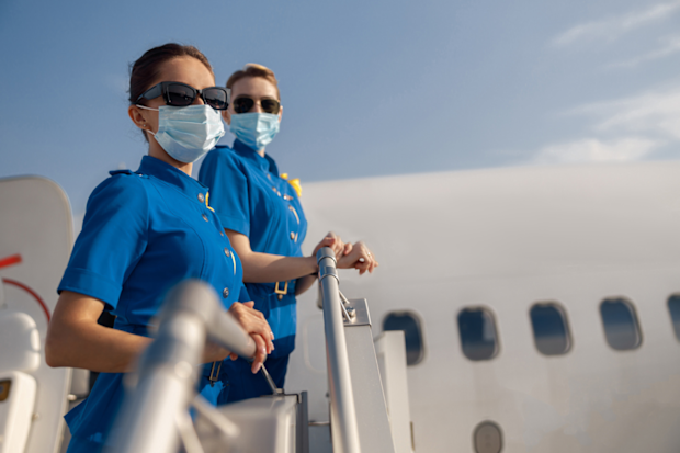 Flight attendants boarding plane wearing coronavirus face mask