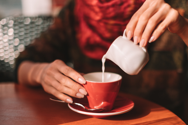 Pouring milk into a cup of tea