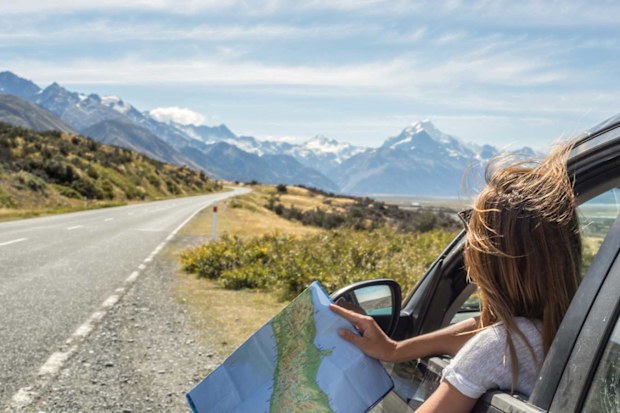 Woman checking paper map on a highway