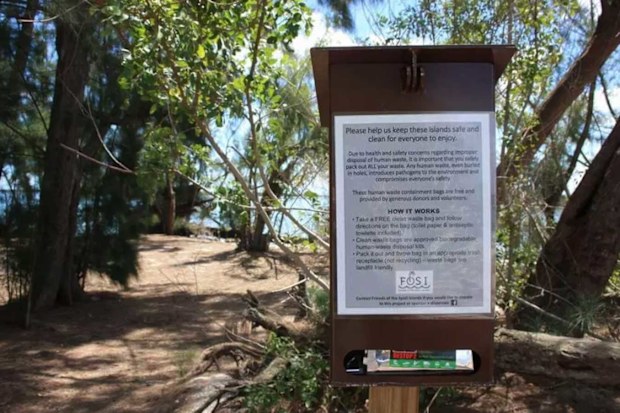 Sign post with waste bags for poo on Florida's Indian River Lagoon