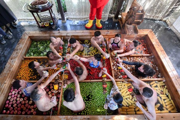 The hot pot shaped hot spring in Hangzhou has vegetables and fruits, including lettuce, chilis, tomatoes, apples, bananas, mushrooms and corns.