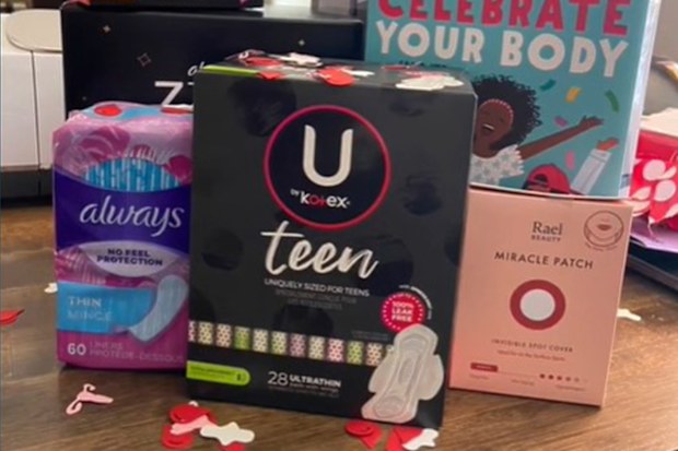 Pads and other menstrual supplies stacked together for a period party.