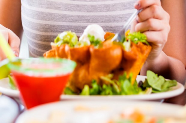 Woman eats Mexican taco salad