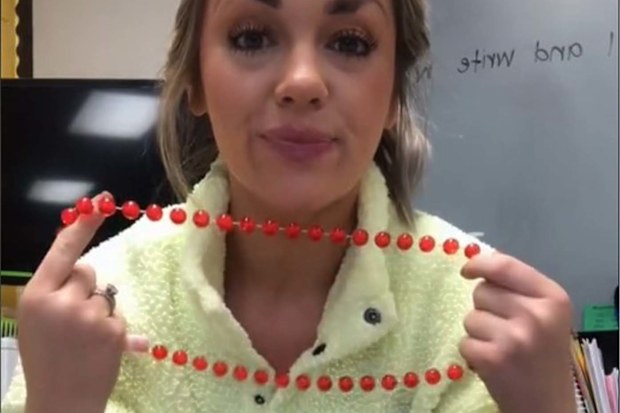 Teacher showing her red necklace to the camera