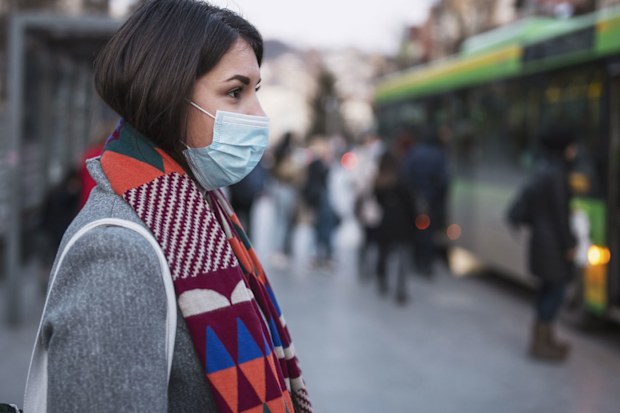 Woman in face masks waits for a bus