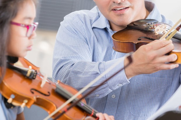 Man teaching girl violin