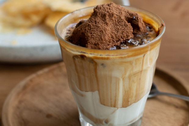 Stock image of milk with a heaped spoonful of Milo on top