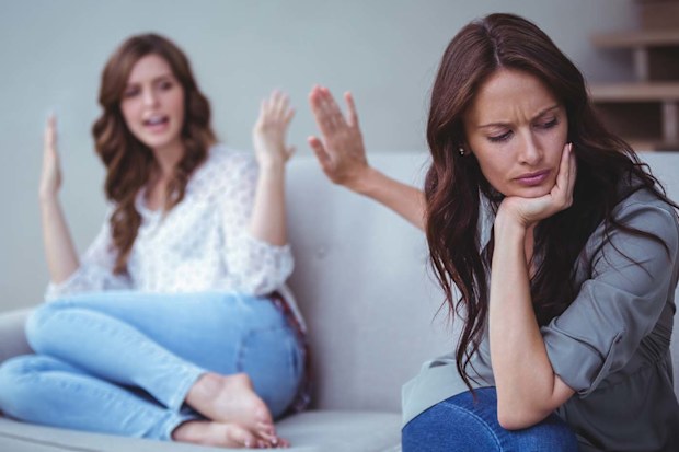 Two women sitting on the couch in the middle of an argument.