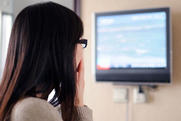 Woman watching the news on TV.