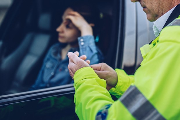 Woman being pulled over by police while driving.