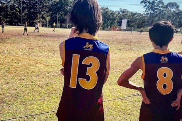 LJ's son at an AFL match on sidelines