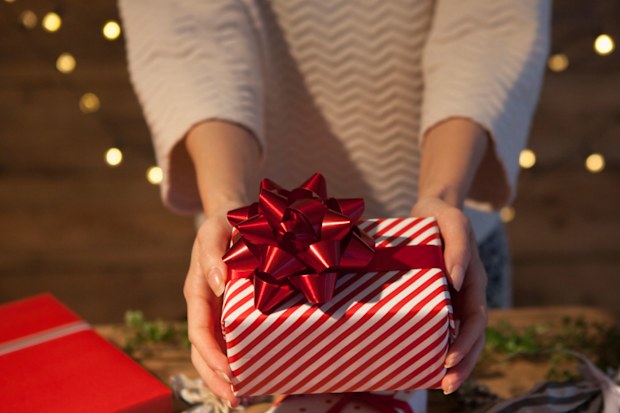 Woman holding wrapped Christmas present 1