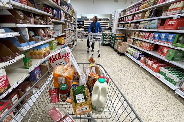 Trolley in supermarket carrying different food items.