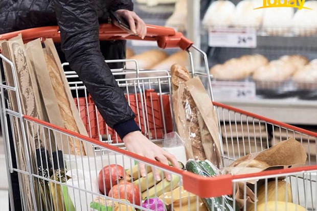 Woman filling trolley with groceries