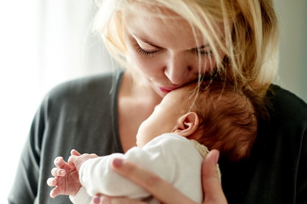 Mum kissing newborn baby