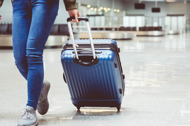 Woman in international airport walking with luggage