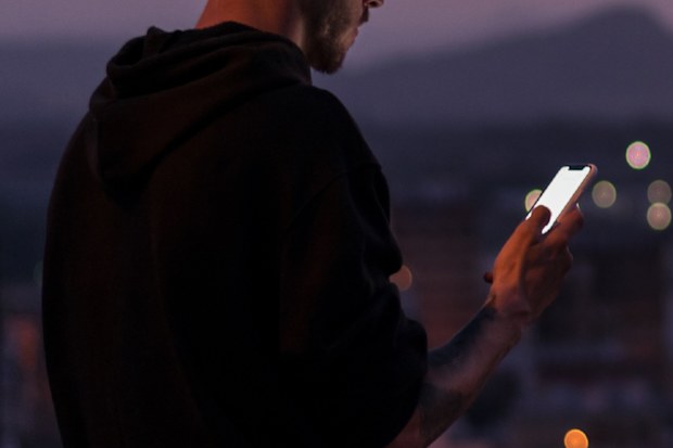 Man on smart phone outdoors at night