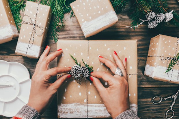 Woman wrapping Christmas presents in brown paper
