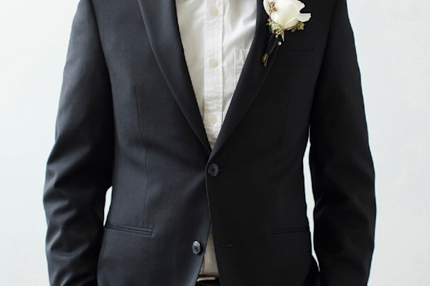 Groom standing in tux