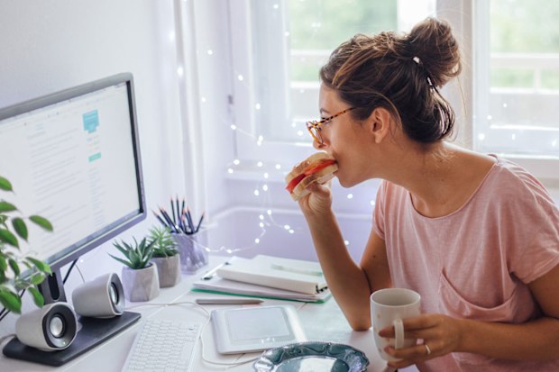 Woman eating while working from home.