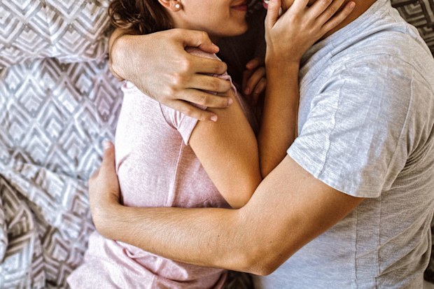 Woman and man cuddling in bed