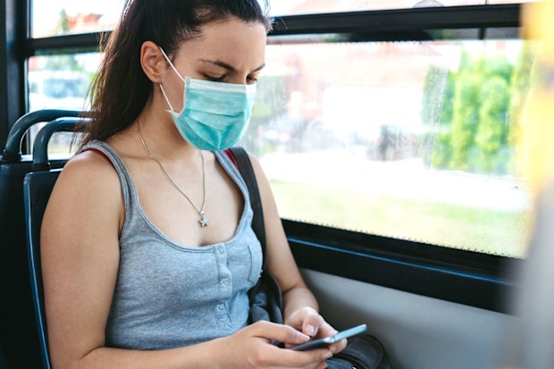 Young woman wearing face mask on public transport.