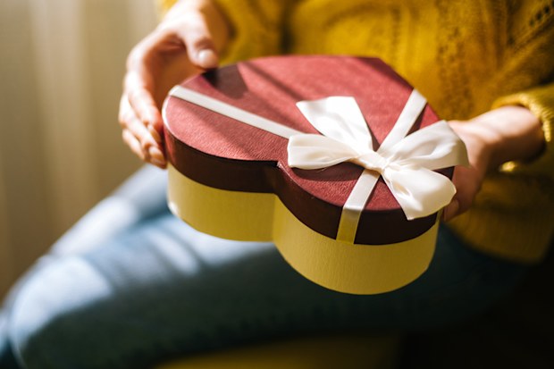 Young woman holding valentine day gift box