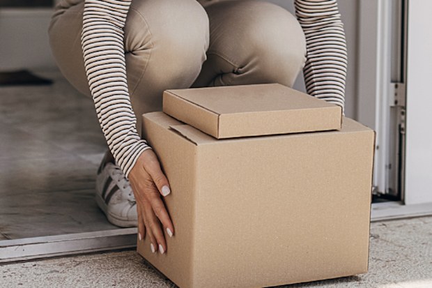Woman retrieving package at front door
