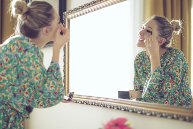 Woman getting ready in front of mirror