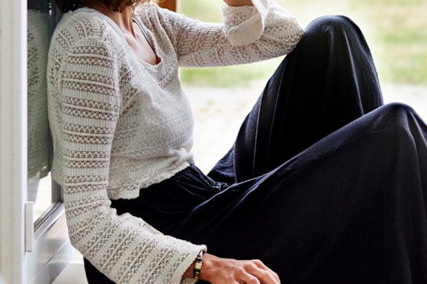 Woman sad sitting on floor with cup of tea