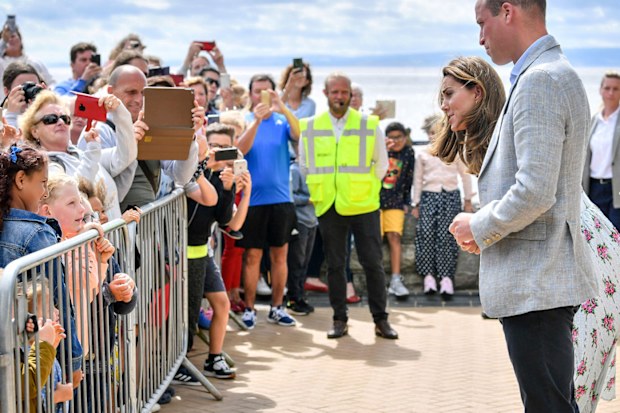 Britain's Prince William and Kate, the Duchess of Cambridge talk with members of the public in Barry Island, Wales, Wednesday Aug. 5, 2020, during their visit to speak to local business owners about the impact of COVID-19.