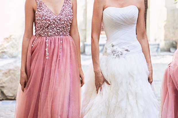 bride standing with bridesmaid wearing a pink dress