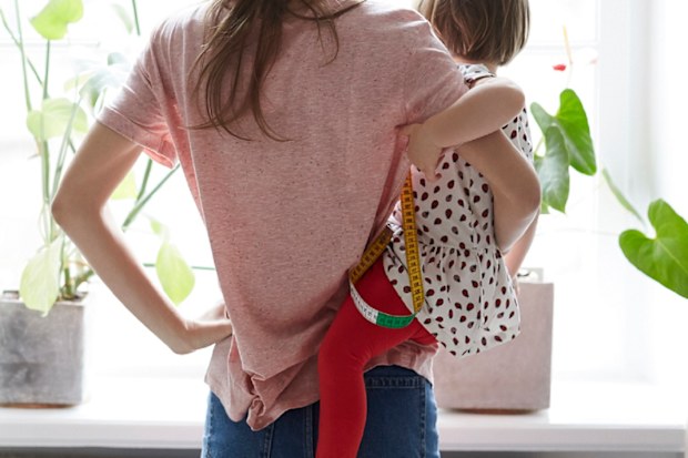 Mother standing at window holding toddler