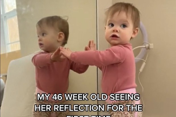 Baby discovers her reflection in the mirror.