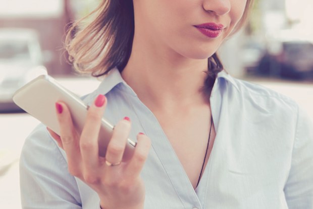 Woman holding phone, looking unimpressed